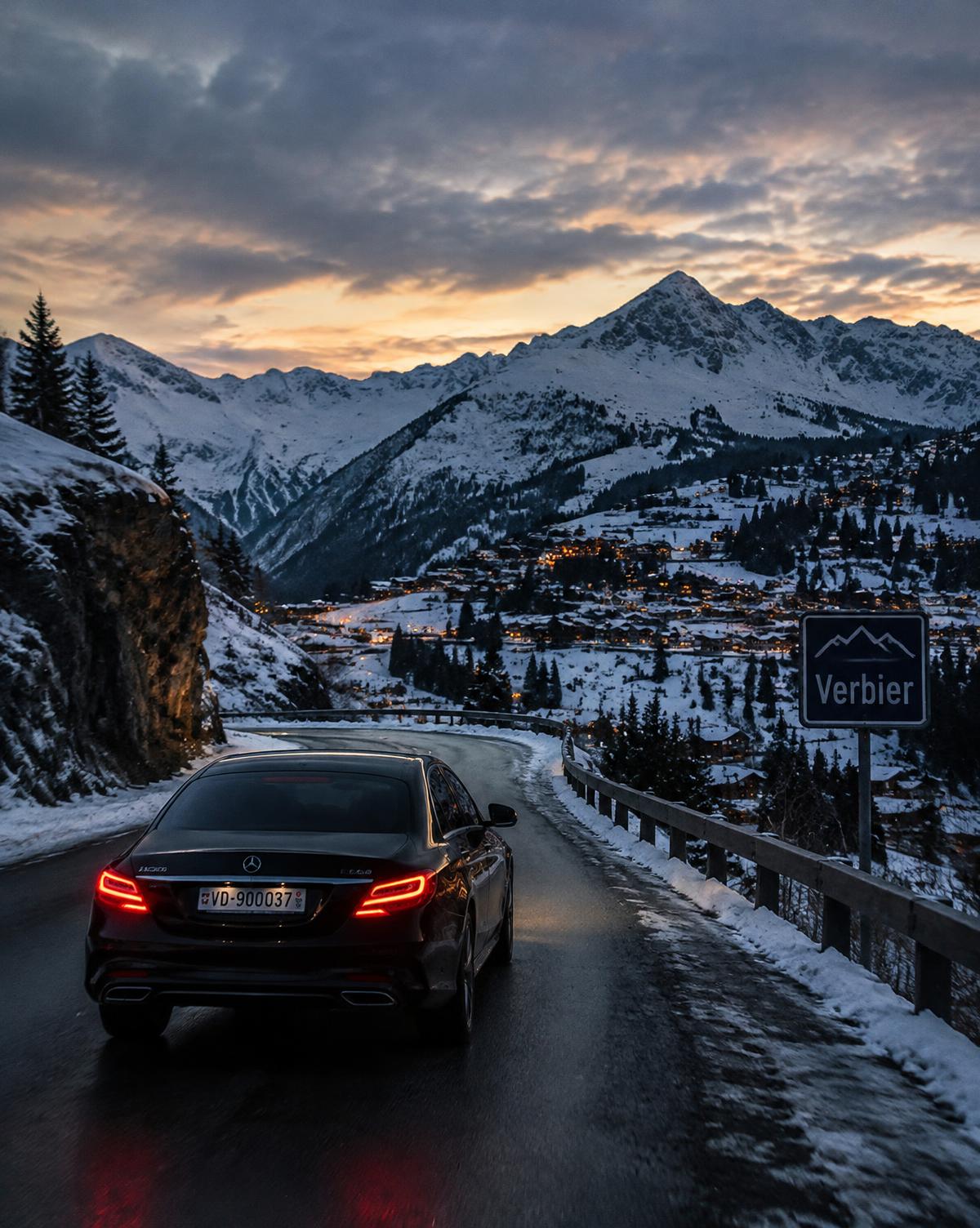 Berline noire sur une route alpine enneigée en direction de Verbier